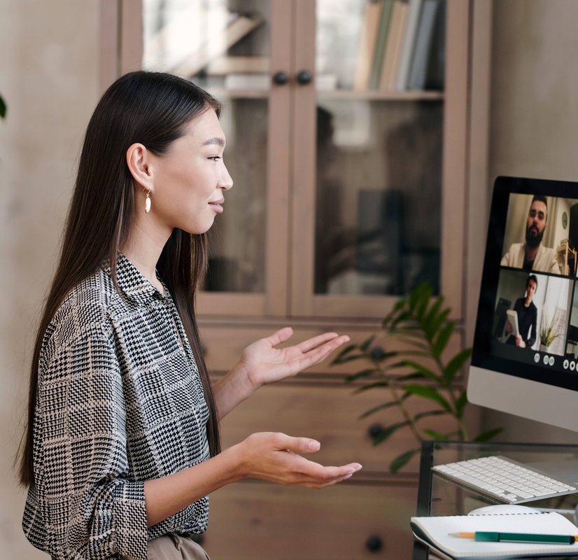 Woman presenting to team during video conference meeting on desktop